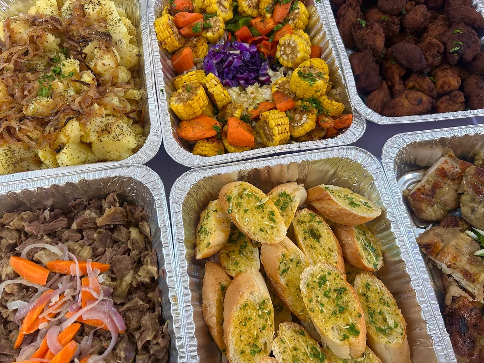 Sharing trays of vegetables, sliced bread and prepared meat dishes